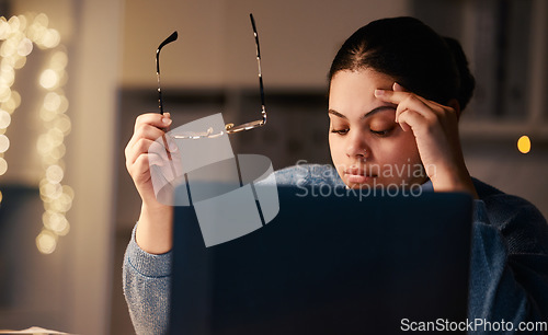 Image of Black woman, headache and home office laptop of a student with stress and burnout. Night, online university project and anxiety of a young female with glasses and blurred background in the dark