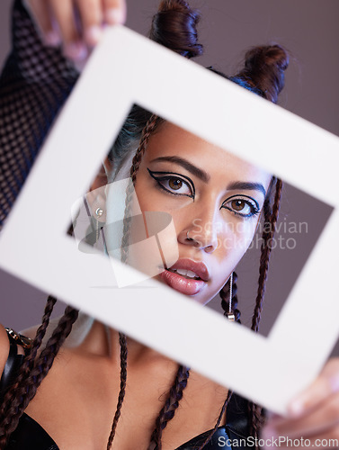 Image of Fashion, frame and portrait of a woman in a studio with a grunge, edgy and goth outfit and makeup. Stylish, beauty and female model with a trendy, cool and emo style isolated by a gray background.