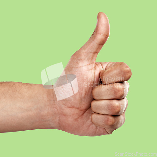 Image of Hands, thumbs up and like emoji, yes sign or agree gesture against a green studio background. Hand of person showing thumb for success, winning or support for luck, good job or thanks in trust