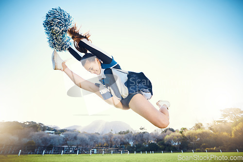 Image of Sports, performance and woman cheerleader jumping while performing a routine on the field at an arena. Fitness, exercise and female doing a trick or skill while training or practicing for the show.