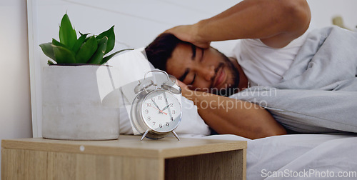 Image of Stress, insomnia and man in bedroom, anxiety and depression with mental health problems. Male, guy and sleepless in bed, tired and overthinking with fatigue, alarm clock and frustrated with issues