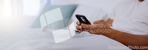 Image of Typing, bed and hands of a man with a phone for social media, communication and chat. Contact, internet and guy scrolling on a mobile app for messages, reading emails or notification in the bedroom