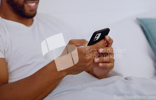 Image of Typing, bed and hands of a man with a phone for social media, communication and chat. Contact, internet and guy scrolling on a mobile app for messages, reading emails or notification in the bedroom