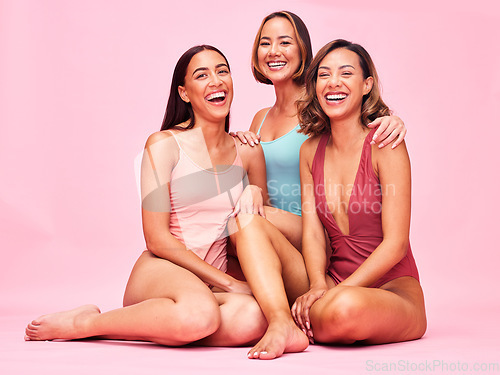 Image of Diversity, bikini and group of happy women in studio, sitting together with smile and body positivity. Beauty, fun summer fashion and swimwear models with self love, equality and pink background.