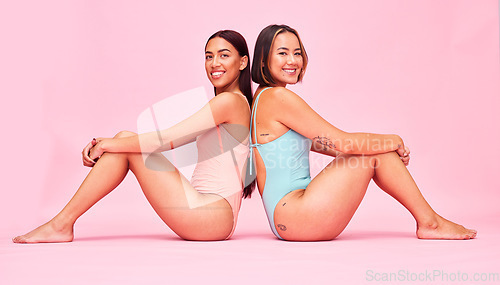 Image of Diversity, swimwear and women in studio portrait, sitting together with smile and fun body positivity. Beauty, summer fashion and happy bikini models with self love, equality and pink background.