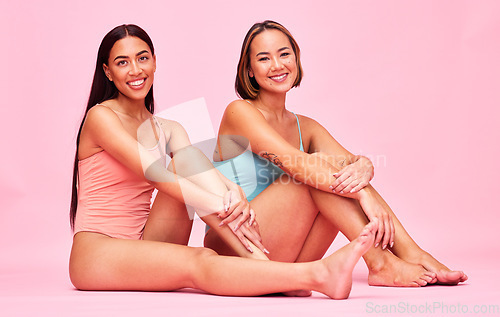 Image of Diversity, swimwear and portrait of women in studio, sitting together with smile and fun body positivity. Beauty, summer fashion and happy bikini models with self love, equality and pink background.