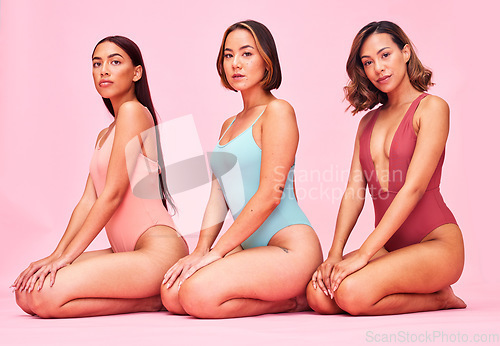 Image of Beauty, body and portrait of group of women in studio, sitting together with diversity and bikini. Underwear, summer fashion aesthetic and swimwear models with self love, equality and pink background