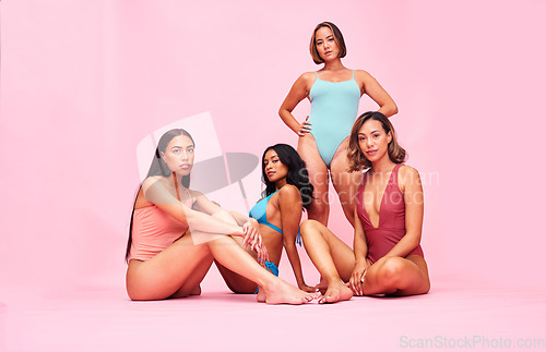 Image of Friends, portrait and women in swimwear in studio for wellness, beauty or self love. Body positive, swimming costume or fashion swimsuit and model group on pink background for diversity and inclusion