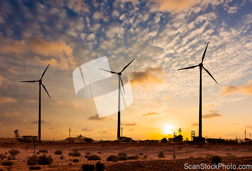 Image of Wind generator turbines sihouettes on sunset