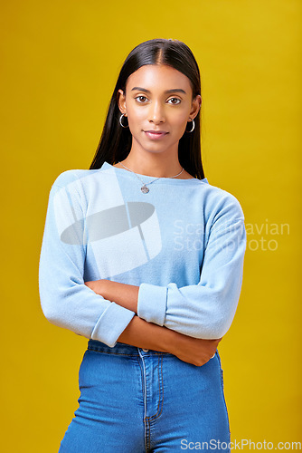 Image of Arms crossed, fashion and student with portrait of woman in studio for future, pride and serious. Youth, confident and college with Indian person on yellow background for learning and trendy style