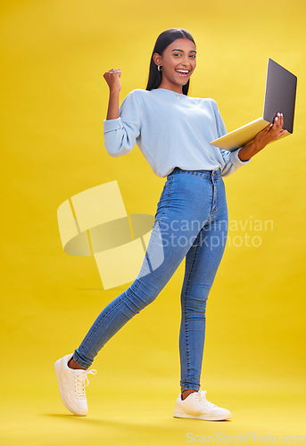 Image of Woman, student and winner on laptop for success, university news and e learning results or opportunity in studio. Person in college portrait with yes, wow or winning on computer and yellow background