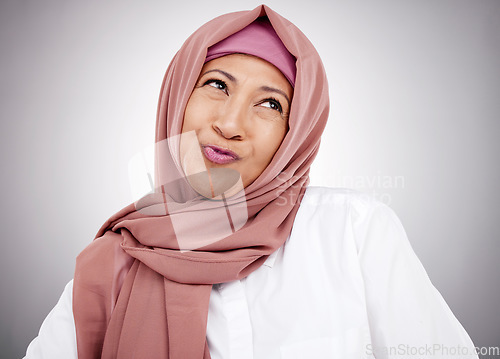 Image of Smile, pouting and a Muslim woman on a studio background with hijab for happiness. Funny, thinking and a mature Islamic person or model with an expression for comedy, goofy or silly on a backdrop