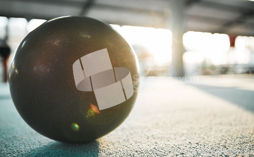 Image of Gymnastics ball on floor for sports, fitness and lens flare with mockup for exercise, performance or rhythmic dance. Light, ground and aerobics equipment in gym, arena or workout space with sunshine.