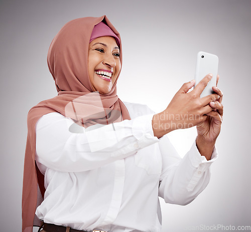 Image of Woman, muslim selfie and happy in studio for social media, influencer blog with fashion and hijab. Islamic person from Saudi Arabia in profile picture photography and clothes on a white background