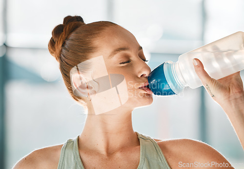 Image of Gym, relax or woman drinking water on break after exercise, workout or fitness training in health club. Hydrate, healthy or face of thirsty sports girl athlete with liquid for wellness or hydration