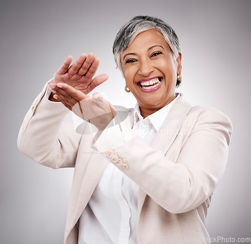 Image of Happy, money gesture and portrait of woman in studio with cashback, prize or financial freedom. Smile, excited and elderly female model with finance hand sign or emoji for savings by gray background.