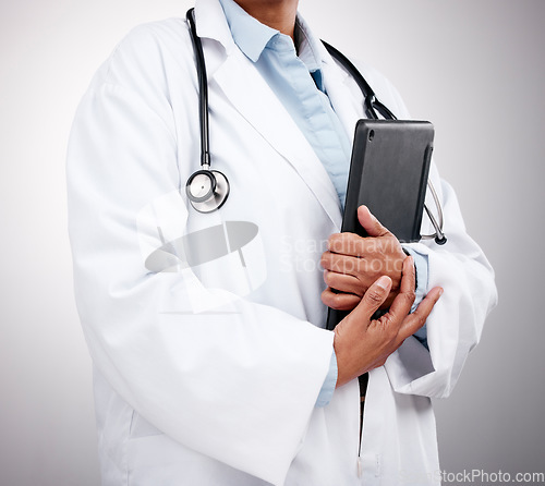 Image of Tablet, technology and hands of doctor in studio for healthcare services, telehealth support and help. Closeup of medical worker, digital connection and consulting clinic research on gray background