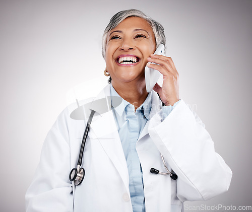 Image of Phone call, doctor and woman in studio for happy conversation, medical consulting or telehealth contact. Mature surgeon, laugh or talk on mobile in communication, support or advice on gray background