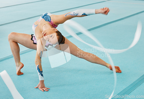 Image of Woman, ribbon gymnastics and dance for performance, sports competition and action show. Dancer, rhythm and creative training of athlete with talent, moving with balance and agile flexibility in arena