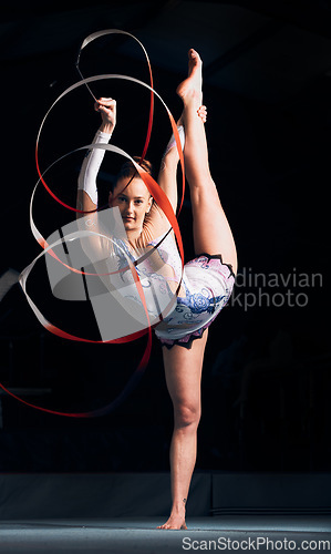 Image of Woman, portrait and balance for ribbon gymnastics, sports performance or competition in dark concert arena. Flexible athlete, dancer and stretching for agile showcase, challenge and rhythm in contest