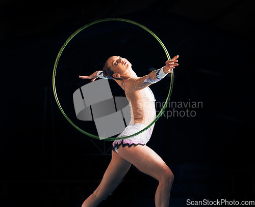 Image of Dance, training with a gymnastics hoop and a woman in the gym for a performance showcase or practice. Fitness, energy and concert with a female athlete on a dark background for routine or recital