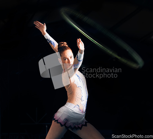 Image of Fitness, energy with a gymnastics hoop and a woman in the gym for a performance showcase or practice. Dance, training and concert with a female athlete on a dark background for routine or recital