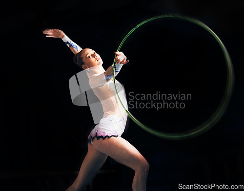 Image of Portrait, training with a gymnastics hoop and a woman in the gym for a performance showcase or practice. Fitness, dance and concert with a female athlete on a dark background for routine or recital