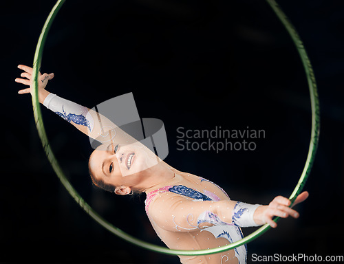 Image of Portrait, concert with a gymnastics hoop and a woman in the gym for a performance showcase or practice. Training, fitness and energy with a female athlete on a dark background for routine or recital