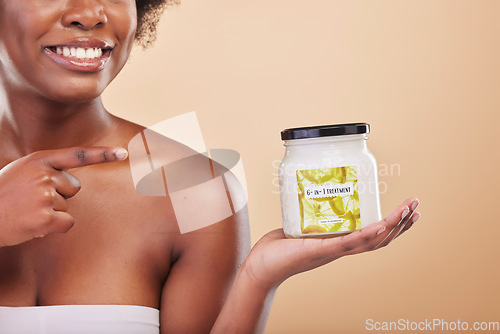 Image of Hand, pointing and product for beauty, treatment or antiaging with a woman in studio on beige background. Skincare, container and advertising or marketing a lotion for aesthetic wellness or body care