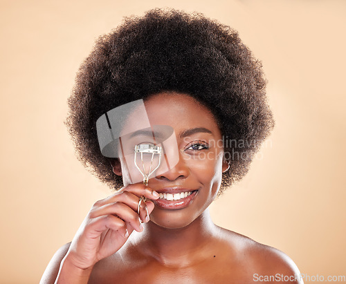 Image of Smile, portrait and black woman with eyelash curler for makeup, wellness and beauty on a backdrop. Happy, headshot and an African girl or model with a cosmetics tool for lashes on a studio background