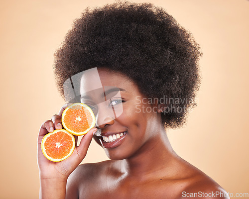 Image of Orange skincare, portrait and woman on studio background for natural cosmetics, healthy benefits and nutrition. Happy african beauty model with citrus fruits for vitamin c, detox and eco dermatology