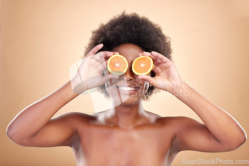 Image of Orange fruits, skincare and woman on studio background for natural cosmetics, healthy benefits and nutrition. Happy african beauty model cover eyes with citrus for vitamin c, detox or eco dermatology