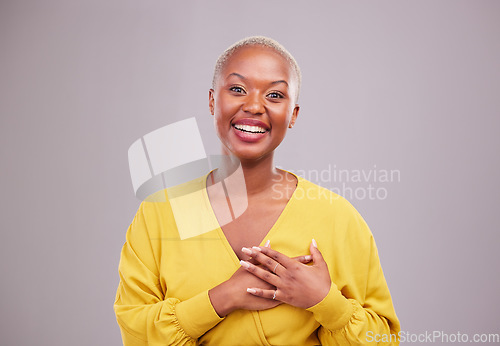 Image of Thank you, smile and portrait of a black woman in a studio with sweet, happy and positive attitude. Empathy, gratitude and young African female model with grateful gesture isolated by gray background