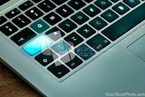 Image of Laptop, keyboard and shift key glow on a desk closeup for networking, typing or blogging in an office. Computer, technology and email connection with futuristic web browsing on a table from above