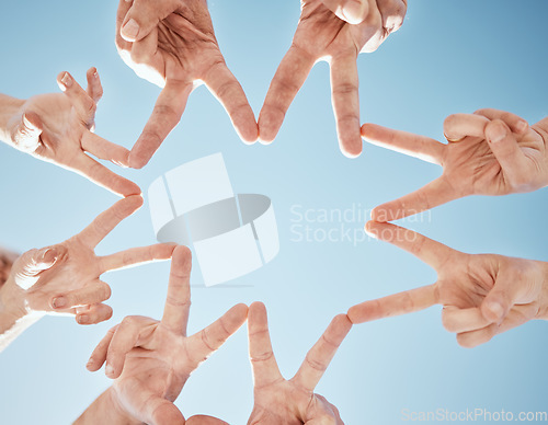 Image of Hands, star and blue sky, support and solidarity with team huddle, community and V sign with connection. Social, goals and mission with group of people outdoor, cooperation and synergy with low angle