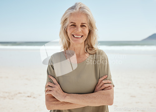 Image of Beach portrait, arms crossed and senior woman relax for outdoor wellness, nature freedom or travel holiday in Canada. Sand, ocean sea water and elderly person smile for retirement vacation happiness