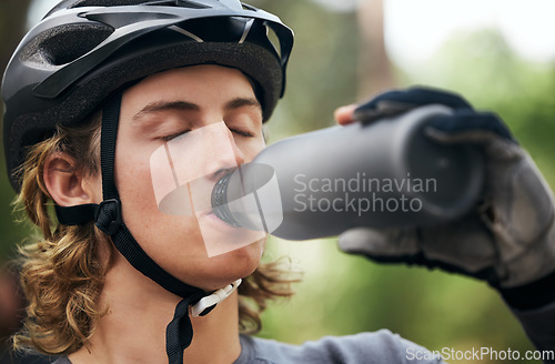 Image of Forest, cyclist and man drinking water, fitness and wellness with hydration, exercise and workout. Healthy person, athlete or biker in the woods, refreshing or outdoor with liquid, training or helmet