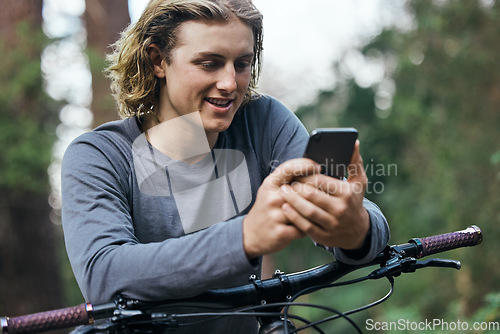 Image of Phone, bicycle and man in forest, smile and social media, internet or sport training. Smartphone, bike and happy person in woods, cycling for healthy body on app and eco friendly transport to travel