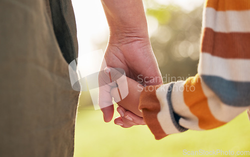 Image of Parent, child and holding hands for walking in park for support, trust and care together or bonding in nature. Love, comfort and mother help kid in the morning sunshine with kindness on weekend