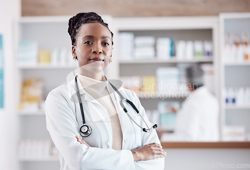 Image of Pharmacy, pharmacist or portrait of black woman with arms crossed in healthcare clinic or drugstore. Proud nurse, wellness or confident African doctor by medication or medicine on shelf ready to help