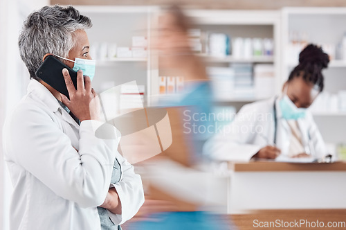 Image of Woman, pharmacist and phone call with face mask in Telehealth, consultation or conversation at pharmacy. Female person or medical healthcare professional talking on mobile smartphone in online advice