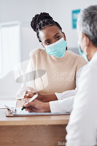 Image of Face mask, doctor or nurse consulting a patient in meeting in hospital writing history or healthcare record. People, medical or nurse with black woman talking or speaking of test results or advice