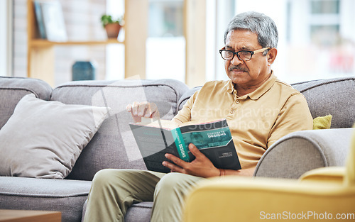 Image of Home, relax and senior man with a book, retirement and calm with a story in a living room. Old person, calm and pensioner in a lounge, novel or literature with a hobby, self help or reading on a sofa