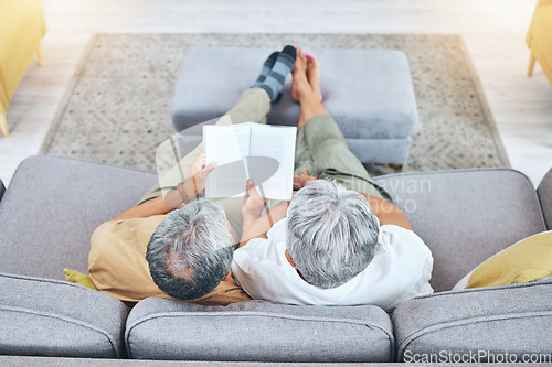 Image of Relax, retirement and a senior couple reading a book on a sofa in the living room of their home from above. Love, storytelling and elderly people taking a break to study for knowledge or a hobby