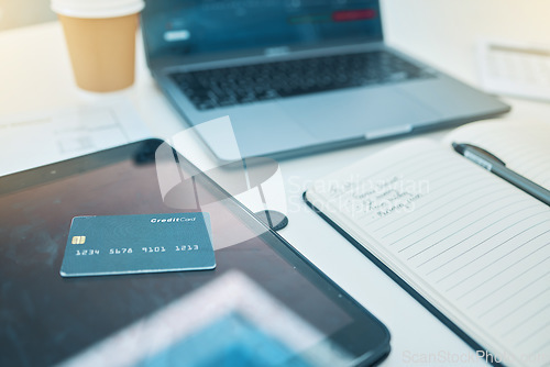 Image of Desk, technology and a credit card with a notebook for work, planning business or finance. Closeup, ecommerce and notes for a corporate or accounting goal on a table for a payment on a tablet or pc