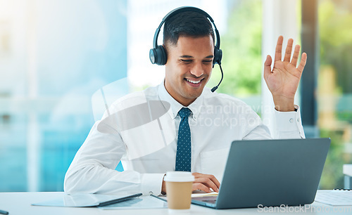 Image of Call center, laptop and man wave in video in customer service, support or help desk office. Happy, hello and sales agent in webinar communication, consulting and telemarketing in online conference