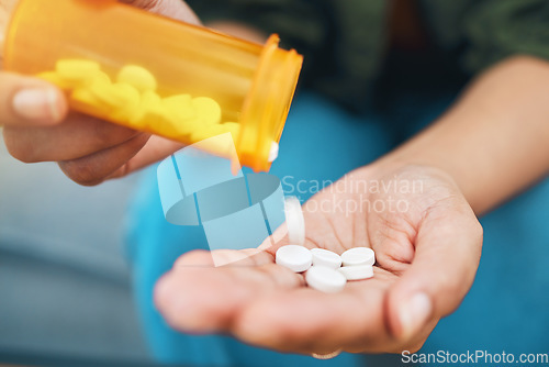 Image of Hand, bottle and pills, closeup of drugs for health and sick person, wellness supplements and vitamins. Healthcare, pharmaceutical tablet and plastic container, antibiotics and treatment for illness