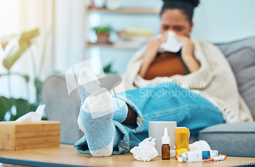 Image of Woman, sick and pills, allergies and medicine with feet on table, healthcare and sinus infection. Virus, bacteria and sneezing, pharmaceutical drugs for illness and tissue, relax on sofa and health