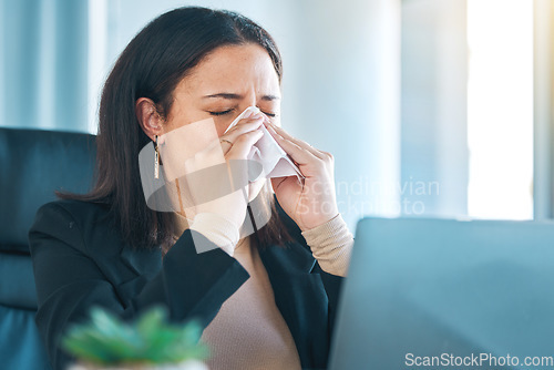 Image of Tissue, sneeze and blowing nose with a business woman in her office for sick leave from a corporate company. Health, allergy or cold and flu virus with a young employee in her professional workplace