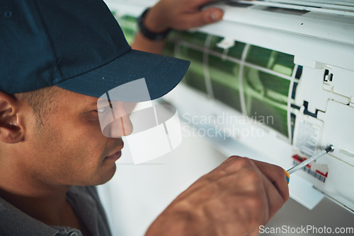 Image of Face, hand and a man for aircon repair or maintenance in an office for circulation or central heating. Construction, tools or screwdriver with an engineer working on an air conditioning unit closeup